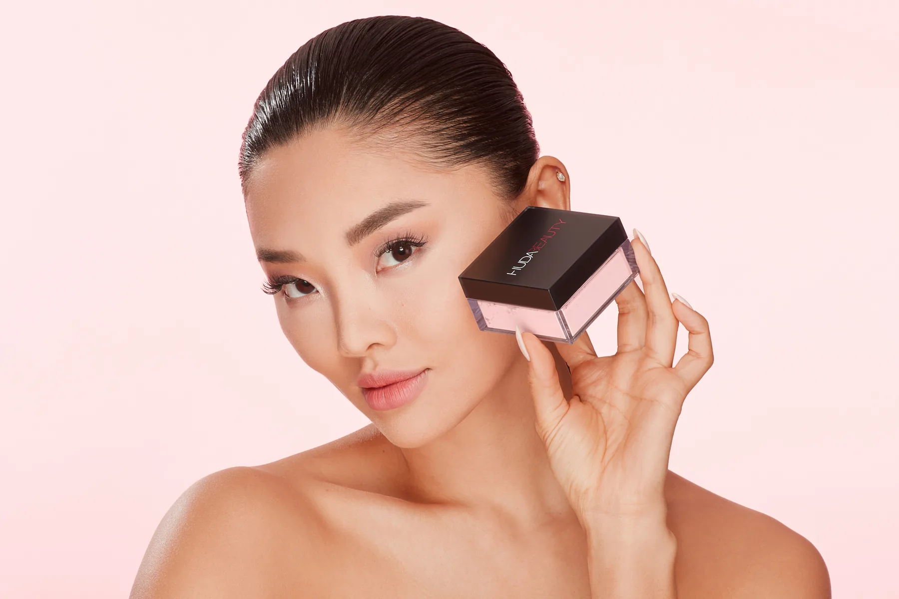 Beauty model holding a Huda Beauty Cherry Blossom blush compact, campaign photography by Aleksandar Pasaric