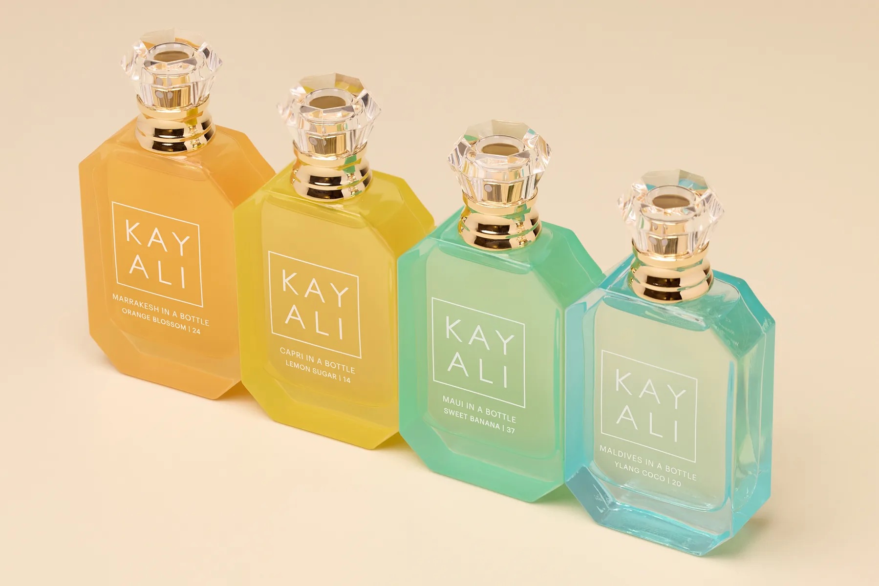 Row of Kayali fragrance bottles in graduating colours, campaign still-life by Aleksandar Pasaric